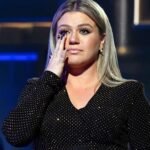 Kelly Clarkson wipes away tears on stage after show cancellations connected to the passing of her ex-husband, Brandon Blackstock.